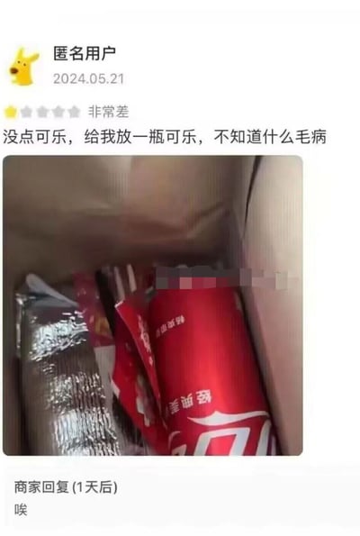 这是一张来自外卖平台的用户评价截图，匿名用户在2024年5月21日对所购外卖给出一星“非常差”的评价，理由是自己并未点购可乐，但收到的餐品中却包含一瓶可乐，用户对此表示不满并附上了餐品实拍图，图中可见餐盒内的红色可乐杯与其他餐品；商家在1天后仅回复了一个“唉”字，简短的回复透露出商家对于此次餐品配送失误的无奈情绪，整体场景展现了外卖服务中常见的餐品错配问题及双方的反应。