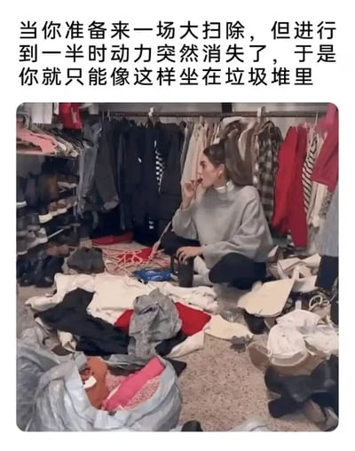 这是一张图文结合的搞笑梗图，采用顶部配文加底部实拍图的形式。顶部文字点明内容主题，描述大家做家务时常遇到的状况：准备大扫除但做到一半突然失去动力，只能坐在垃圾堆里；下方实拍图中，一名扎高马尾、穿灰色上衣的女性身处挂满衣物的衣帽间内，地面散落着大量待整理的衣服、包包、鞋子等杂物，她盘腿坐在杂乱的物品中间，一边吃东西一边神态放空，完美对应了配文描述的状态，极具生活化共鸣感。
