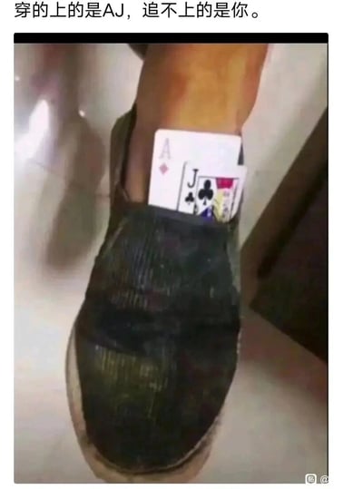 这是一张充满反差感的创意搞笑梗图，画面主体是一只穿着破旧黑色鞋子的脚，鞋口处插着扑克牌方块A和梅花J，利用字母缩写谐音知名球鞋品牌AJ，搭配图上方的配文“穿的上的是AJ，追不上的是你”，既用低成本的滑稽方式“实现”了拥有AJ的调侃，后半句又带有自嘲式的伤感，暗指在感情或生活中面临的求而不得的无奈，将幽默与心酸结合，形成独特的梗图效果。