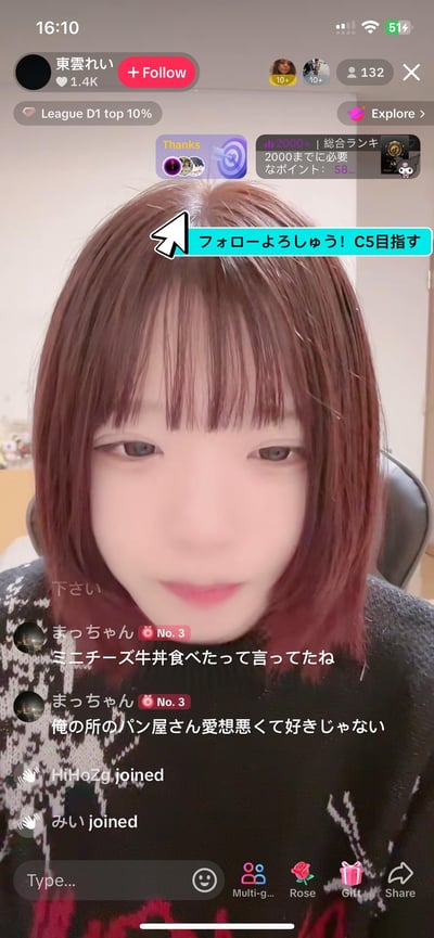 这是一张竖屏手机端的直播画面截图，主播是名为東雲れい的日本女生，留着红棕色齐肩短发，面带温和的微笑看向镜头，正在进行直播互动。界面显示主播拥有1.4K粉丝，当前直播间有132名观众，主播在画面上方的提示栏请求观众关注，目标是提升到C5等级。评论区有观众「まっちゃん」留言分享日常：提及自己吃了迷你芝士牛丼，还吐槽家附近面包店的店员态度恶劣；同时有新观众「HiHoZg」「みい」进入直播间的提示。界面还包含直播平台的等级标识「League D1 top 10%」、等级升级所需点数提示、关注按钮、礼物图标、观众人数等UI元素，整体呈现轻松的日常直播互动氛围。