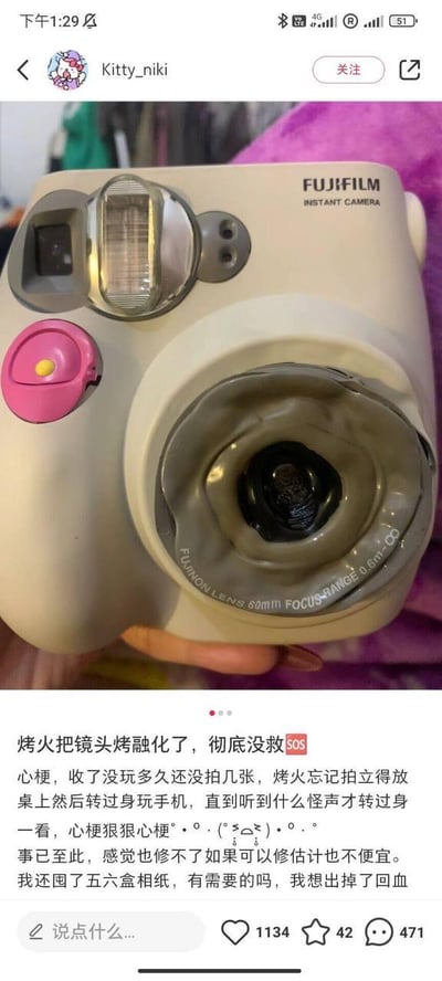 社交媒体用户Kitty_niki发布的图文内容，展示了一台富士（FUJIFILM）拍立得相机的损坏情况。相机镜头因靠近火源被烤融化，呈现变形焦黑状态。用户配文描述了事故经过：烤火时忘记将相机移开，转身玩手机期间听到怪声，发现镜头已彻底损坏，表达了“心梗”（心痛）的情绪，并表示相机已无法修复，希望出售剩余的五六盒相纸以“回血”（弥补损失）。