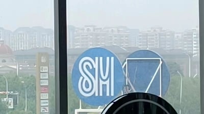 这张图片展示了从室内透过玻璃窗拍摄的城市景观。窗外可以看到密集的城市建筑群，远景建筑在轻微的雾气中显得有些朦胧。前景中有两个蓝色圆形标志特别醒目，左侧标志上有白色的"SIYI"字样，右侧标志则是一个几何图形设计。图片下方还能看到部分黑色圆形物体的边缘，可能是室内的某种设备或家具。整体画面呈现出一种平静的城市氛围。