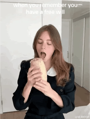 这是一张动态GIF图，画面中一位身着深色带白领上衣的女生，张大嘴巴做出要啃咬手中法棍面包的夸张动作，上方配有英文文字“when you remember you have a free will”（当你想起你拥有自由意志的时候）。用极具反差感的随性动作，调侃突然意识到可以自主决定行为、随心所欲做想做的事时的放飞状态，充满搞笑趣味。