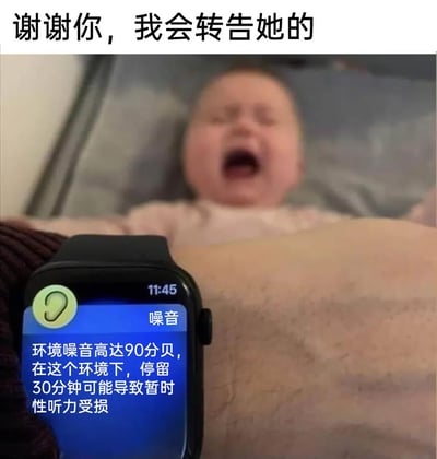 这是一张充满趣味的网络梗图，图片顶部配有文字“谢谢你，我会转告她的”，前景是一只Apple Watch，屏幕显示时间为11:45，同时弹出噪音提示：“噪音 环境噪音高达90分贝，在这个环境下，停留30分钟可能导致暂时性听力受损”，背景中是一名平躺的婴儿，正处于大哭状态，婴儿的哭声被智能手表识别为高噪音，使用者用“谢谢你，我会转告她的”来回应手表的提示，将智能设备的严谨提示与生活化的带娃场景结合，形成了幽默的反差，用这种方式调侃婴儿哭声的“音量威力”，引发网友的共鸣与笑点。