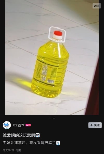 图片中展示了一瓶黄色的洁厕净，瓶身印有中文标签“洁厕净”，瓶盖为红色，带有白色提手，放置在白色大理石纹理的瓷砖地面上。图片下方是网友“lzz西木”的评论，称因洁厕净颜色与食用油相似，被老妈要求拿油时误拿了洁厕净而挨骂，引发对产品外观设计易混淆的吐槽。