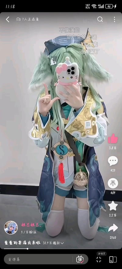 这是一张抖音短视频的竖屏截图，画面中一位coser身着游戏《崩坏：星穹铁道》中角色藿藿的全套服饰，戴着浅绿色带兽耳的假发，跪坐着手持带有Hello Kitty造型手机壳的手机自拍，同时比出L型手势，面部被手机遮挡。视频标题为「藿藿的要漏出来啦」，结合角色名字「藿藿」与「糊糊（漏出的液体）」的谐音制造搞笑梗，弹幕内容有「不像演的」「漏出来的我喝」「逆天搜索」「还真漏了」，进一步玩梗互动。视频作者为抖音账号「妲己妲己_」，拥有5.1万粉丝，该视频播放量达30.9万，互动数据显示有3.8万点赞、425条评论、489次转发、2.2万收藏、2560次分享。
