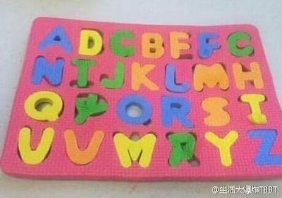这是一块粉色底板的儿童英文字母拼图玩具，属于幼儿早教认知类用品。图中的字母大多没有放置在对应的凹槽内，比如F放在了B的凹槽、Q放在了O的凹槽，还有部分字母重复出现、部分凹槽空缺，整体呈现出一种混乱的状态，像是孩子随意摆放后的样子。