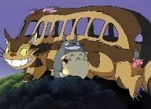 画面中展示了《龙猫》中的经典场景：大型的猫巴士有着棕色的车身，形似猫咪，黄色的眼睛带着大大的微笑，背部点缀着粉色的花朵。它身旁站着体型较小的灰色龙猫，二者共同立于长满绿色植被的山丘上，背景是宁静的紫色天空，整体氛围温馨治愈。