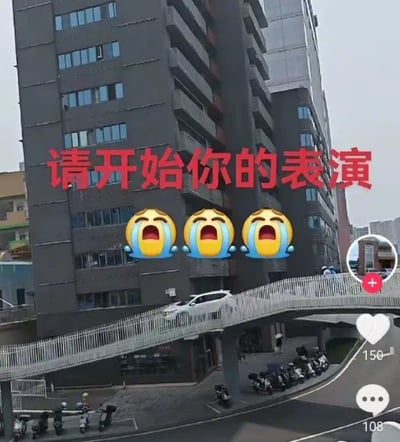 这张图是一张恶搞表情包，画面中一辆白色汽车开上了人行天桥，形成了一副荒诞的场景。配文为“请开始你的表演”并附有三个大哭表情，表现出对即将发生的“事故”或“惊人操作”的无奈与搞笑心情。文字具有调侃意味，常用于形容某人要做出惊人举动时的气氛烘托。这张图有一定的“双关”与调侃意味，将严肃的交通违章或出格行为与综艺/表演结合，制造反差萌。