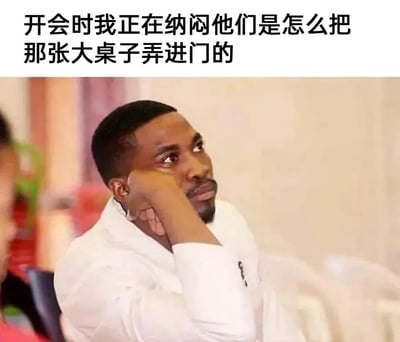 图片中一名穿着白色衬衫的男子坐在会议室里，单手托腮，侧头望向一边，脸上带着若有所思的表情。图片上方配有文字：“开会时我正在纳闷他们是怎么把那张桌子弄进门的”，幽默地展现了人们在会议中走神、思考无关紧要问题的场景，充满了职场生活的共鸣感和轻松搞笑的氛围。