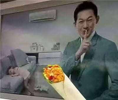 这是一张经过二次创作的P图合成图，画面源自某空调广告的截图：前景是一位身着绿色西装的男士，他将手指抵在嘴边，做出夸张的噤声“嘘”手势；通过视觉错位，画面下方添加的卷饼看起来像是被男士拿着，背景的沙发上有一位女孩正熟睡。这张图利用视觉错位营造出“男士想偷偷吃卷饼，生怕吵醒睡觉女孩”的滑稽场景，没有双关、谐音梗等内容，仅靠错位效果制造搞笑氛围。