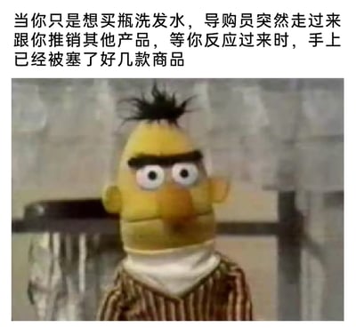 这是一张充满共鸣的搞笑表情包，上方配文描述了一个常见的线下购物尴尬场景：本来只是想买一瓶洗发水，结果被导购员推销其他产品，等反应过来时手上已经被塞了好几款不需要的商品。图中使用了美国经典儿童节目《芝麻街》里的角色伯特的呆滞茫然表情，完美还原了那种被过度推销后脑子空白、不知所措的状态，精准戳中了很多人有过的类似购物经历，引发强烈共鸣。