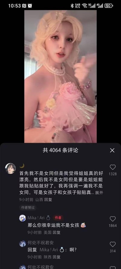 社交媒体截图展示了一位金发人物穿着粉色带花装饰的连衣裙的照片，下方有评论区互动。一条热门评论写道：“首先我不是女同但是我觉得姐姐真的好漂亮，然后我不是女同但是要是姐姐能跟我贴贴就好了，我再强调一遍我不是女同，可是女孩子和女孩子贴贴真...”，作者“Mika! Ari”回复：“那么你很幸运我不是女孩😼”。评论区显示共有4064条评论，整体氛围轻松幽默。