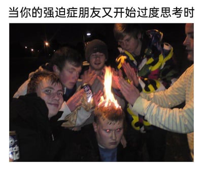 这是一张用于调侃强迫症的搞笑梗图，顶部配有文字“当你的强迫症朋友又开始过度思考时”。画面呈现的是夜晚户外场景下的一群年轻人，其中一名男子的头顶头发被点燃，眼睛还被P成了红色，表情呆滞地坐着；周围的同伴们围着他拍手，有的面带兴奋笑容，整体场景荒诞恶搞。用“脑子着火”的夸张画面，比喻强迫症朋友过度思考时的状态，以荒诞的视觉效果制造笑点，调侃人想太多、过度纠结的状态。