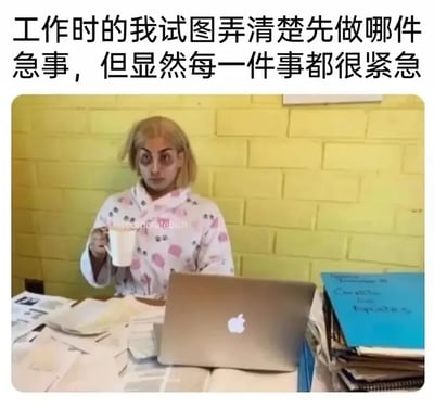 这是一张职场吐槽类的顶配底文图文混排表情包，顶部配文为“工作时的我试图弄清楚先做哪件急事，但显然每一件事都很紧急”；下方实拍图中，一名妆容憔悴、眼神呆滞茫然的金发女性穿着带图案的家居服，坐在堆满杂乱文件、资料的办公桌前，手里举着白色马克杯，面前放着苹果笔记本电脑，画面生动传神地还原了打工人面对大量堆积的紧急工作时，手足无措、不知道该先处理哪项任务的茫然崩溃状态。