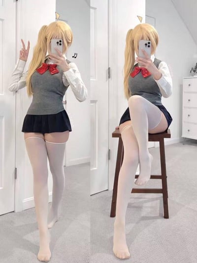 图片展示了一位穿着校服的少女两张不同姿势的自拍对比。左侧图中少女站立着，左手比出剪刀手，右手拿着手机自拍；右侧图中少女坐在凳子上，双腿交叉，同样拿着手机自拍。少女有着金色双马尾发型，穿着白色衬衫、灰色背心、黑色短裙和白色过膝袜，领口系着红色蝴蝶结。背景是一个简约的室内环境，有白色的门和浅色的家具。
