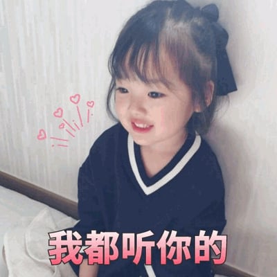 图片中是韩国女童星权律二，她梳着带有黑色蝴蝶结的发型，穿着深蓝色带白色领口的上衣，靠墙坐着，面带微笑，显得乖巧可爱。左脸颊旁有几颗粉色爱心图案装饰，图片底部配有红色文字“我都听你的”，整体营造出顺从、暖心的氛围，是常见的可爱风格表情包。