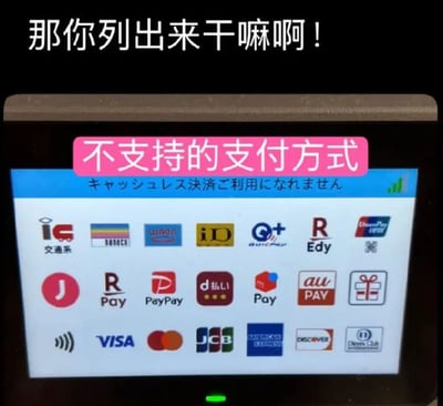 图片展示了一台支付终端的屏幕，屏幕上密集排列着多种支付方式图标（包括Visa、Mastercard、PayPay、JCB等），上方有日文提示文字“キャッシュレス決済ご利用になれません”（无法使用无现金支付），并被粉色标签标注“不支持的支付方式”。屏幕顶部有醒目的白色文字“那你列出来干嘛啊！”，以幽默吐槽的方式表达了对支付终端列出大量不支持支付方式的无奈与困惑。