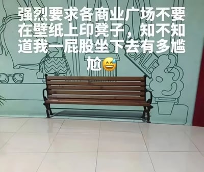图片展示了一个商业广场内的场景，地面是白色瓷砖，中央有一张木质长椅。背景墙为浅蓝色，上面印有手绘风格的线条图案，包括包包、眼镜、标有'SALE'的牌子等装饰元素。图片上方叠加了一段吐槽文字：'强烈要求各商业广场不要在壁纸上印凳子，知不知道我一屁股坐下去有多尴尬 😂'，生动表达了因壁纸图案产生视觉错觉而导致的尴尬经历。