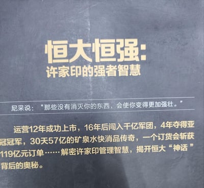 这是一张书籍宣传纯文字图，以深灰色为背景搭配醒目金色文字，核心是推广《恒大恒强：许家印的强者智慧》这本书。图中引用尼采的名言“那些没有消灭你的东西，会使你变得更加强壮”，还列举了恒大曾经的多项亮眼商业成绩：运营12年成功上市、16年后跻身千亿企业军团、4年夺得亚冠冠军、30天创下57亿矿泉水销量传奇、单场订货会斩获119亿元订单等，以此引出书籍将解密许家印的管理智慧，揭开恒大曾经的商业“神话”背后的奥秘。