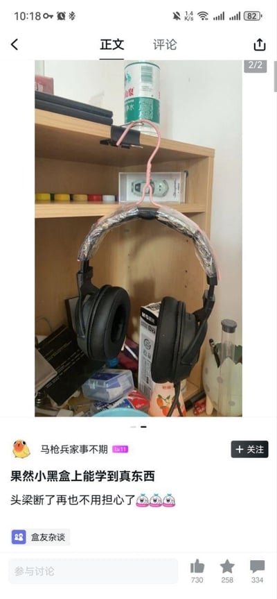 这是一张来自游戏社区小黑盒的用户分享截图，用户「马枪兵家事不期」展示了一个低成本修复断梁耳机的实用小技巧：将头梁断裂的头戴式耳机，通过一个粉色衣架挂在木质柜子的层板上，利用衣架的弧度替代原本断裂的耳机头梁，实现继续使用的目的。用户配文表示「果然小黑盒上能学到真东西，头梁断了再也不用担心了」，还搭配了三个哭笑不得的表情，截图下方显示该内容属于「盒友杂谈」板块，获得了730个点赞、258个收藏以及334条评论，是一个搞笑又实用的生活DIY技巧分享。