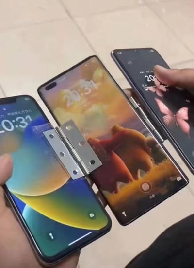 图片展示了三部智能手机通过金属合页铰链被物理连接在一起，形成一个类似多屏折叠的装置。左侧手机屏幕显示时间20:31，中间手机显示20:34，右侧手机显示20:35，三部手机屏幕内容各不相同，有人正在用手指操作右侧的手机。这种创意改造将普通手机组合成类似折叠屏手机的形态，带有明显的DIY趣味。