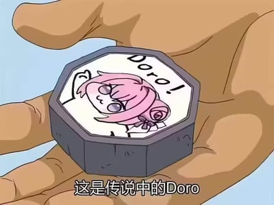 画面中一只手托着一个八角形物体，物体表面绘制着粉色头发、表情呆萌的Doro角色形象，旁边写有“Doro!!”字样，下方配有文字“这是传说中的Doro”。整体为卡通风格的图文混排，展现了源自韩国手游《胜利女神：妮姬》的二创表情包角色Doro。