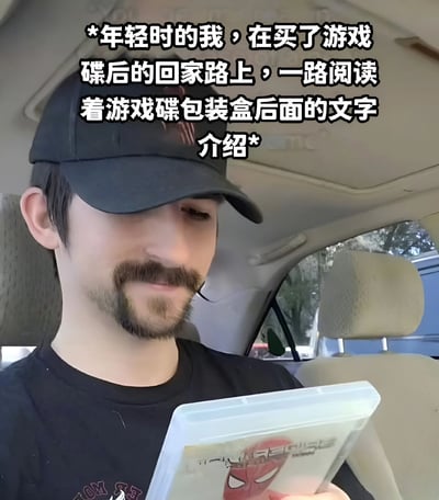 图片展示了一位戴着黑色帽子和黑色T恤的年轻男子坐在汽车内，正专注地阅读手中的游戏碟包装盒。男子留有胡须，表情认真，目光集中在游戏盒上。背景可见汽车座椅和窗外的树木。图片上方有文字说明：'*年轻时的我，在买了游戏碟后的回家路上，一路阅读着游戏碟包装盒后面的文字介绍*'，表达了年轻人购买新游戏后迫不及待了解游戏内容的心情，引发许多玩家的共鸣。