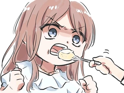 这是一幅卡通风格的单幅插画，画面主体是一位浅棕色长发的女孩，她眉头紧皱、双眼圆睁，嘴巴大张，双手攥紧成拳头，神态看起来气鼓鼓的，却又对着递到嘴边的勺子上的食物张开嘴，呈现出一种嘴硬却又忍不住想吃的反差感。画面右侧是一只拿着勺子的手，勺子上盛着一块类似布丁或蒸蛋的浅黄色食物，女孩穿着带荷叶边的浅色上衣，脖子戴着细项链，整体画风软萌可爱，充满生活化的趣味，没有双关或谐音梗等隐含内容。