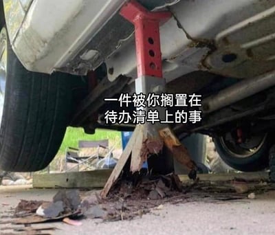 这是一张讽刺拖延症的创意梗图，画面展示了汽车维修场景的一角：汽车下方的千斤顶本该搭配稳定的金属支撑座，实际却用一块已经严重腐烂、断裂的木头替代，木头已经碎成渣状，濒临完全失效，却还在勉强顶着千斤顶的金属部分，场景既荒诞又带有潜在危险。图片中间配有文字“一件被你搁置在待办清单上的事”，用这个即将彻底崩溃的木质支撑，生动比喻那些被长期拖延、一直放在待办清单里却始终不处理的事项——随着时间流逝，这些事项会像这块木头一样，逐渐错过最佳解决时机，变得越来越棘手，最终可能彻底“失控”，精准戳中了有拖延习惯人群的共鸣点，用生活化的荒诞场景传递出对拖延行为的调侃与讽刺。