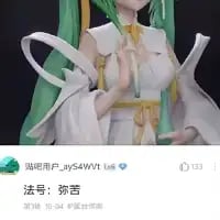 这是一张抖音平台的竖屏截图，展示了一个绿发的初音未来风格手办模型，手办有着浅绿色长发，身穿白色为主、搭配黄色装饰的服饰，姿态端庄。截图下方配文「法号：弥苦」，利用谐音梗，「弥苦」谐音初音未来的日语昵称「米库（miku）」，是对这个经典虚拟偶像的趣味玩梗，制造出反差搞笑的效果。