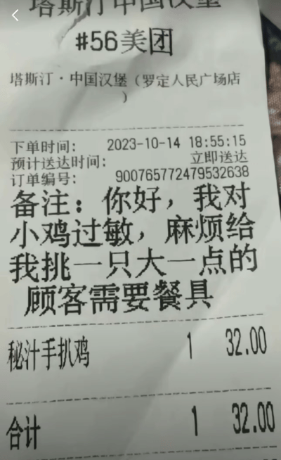这是一张来自塔斯汀·中国汉堡（罗定人民广场店）的美团外卖订单小票，小票显示下单时间为2023年10月14日18:55:15，订单为一份32元的秘汁手扒鸡，预计立即送达。最引人注目的是用户的备注内容：‘你好，我对小鸡过敏，麻烦给我挑一只大一点的’，同时备注需要餐具。这个备注玩了文字梗，将‘小的鸡肉’和‘大的鸡’概念混淆，制造出荒诞的幽默效果，是典型的趣味外卖备注内容。