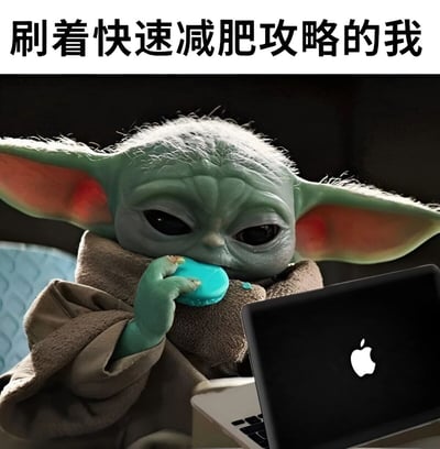 图片上方有黑色文字“刷着快速减肥攻略的我”，下方是《曼达洛人》中的角色Grogu（尤达宝宝）。他穿着棕色的披风，左手拿着一块蓝色的饼干正在食用，右手边放着一台带有Apple标志的黑色笔记本电脑，眼睛专注地看着屏幕。整体画面通过可爱角色的行为与文字形成反差萌，幽默地展现了人们一边看减肥攻略一边忍不住吃零食的矛盾日常。