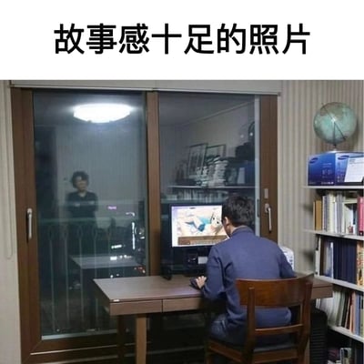 这张照片呈现了充满生活张力的场景：在居家的房间里，一名男性背对着镜头，正聚精会神地看着电脑屏幕上的二次元风格内容；玻璃推拉门外，一位女性正看向他的方向，表情复杂，似乎带着无奈或担忧。房间内的书架、地球仪等陈设让场景更具真实感，画面上方的文字“故事感十足的照片”点出了这张图的核心，它精准捕捉到了当代年轻人的兴趣爱好与长辈观念之间的微妙冲突，容易引发观者的共鸣。