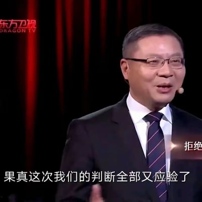 这是一张东方卫视节目视频截图，画面核心人物是学者张维为，他身着深色西装、白色衬衫，搭配带有红色细条纹的深色领带，佩戴眼镜，面带自信的微笑，手部抬起，正处于演讲的状态。画面左上角有“东方卫视 DRAGON TV”的平台标识，左下角显示字幕“果真这次我们的判断全部又应验了”，右上角还露出了部分“拒绝”字样的字幕，背景是暗红色的幕布，整体场景正式，传递出人物对自身判断的笃定态度。